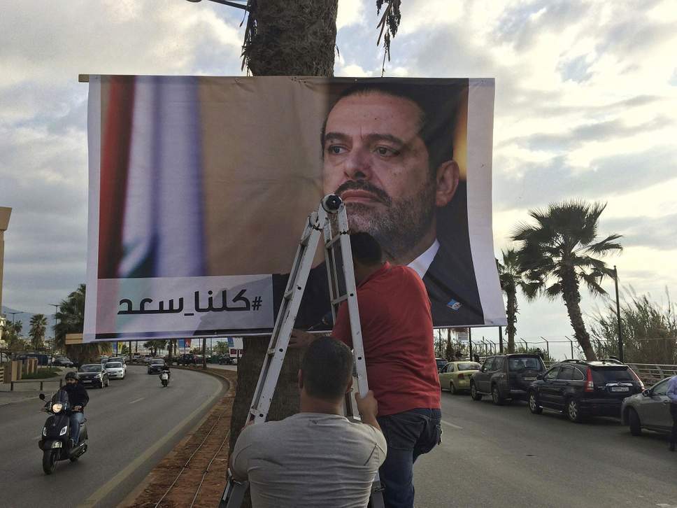 Lebanese workers post signs decrying the Saudi kidnapping of popular prime minister Saad Hariri